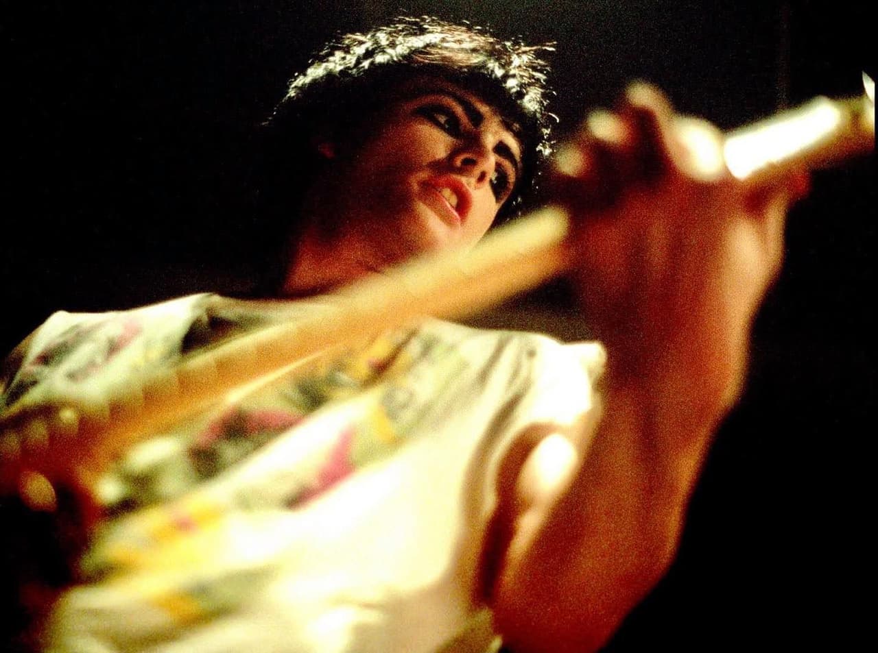 A guitarist mid-set shot on film, warm light catching the strings.