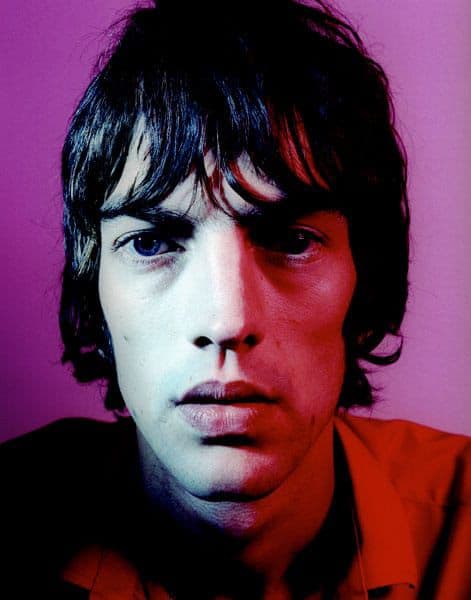 Richard Ashcroft portrait lit in red against a purple background.